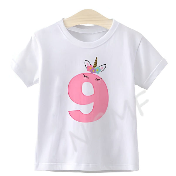 T-shirt blanc pour enfant, décoré d'un grand chiffre 9 rose orné d'un motif licorne avec des fleurs, suspendu à un cintre en bois. Idéal pour un anniversaire de 9 ans., 45502332141823,45502332174591,45502332207359,45502332240127,45502332272895,45502332305663,45502332338431,45502332371199 | Licorne Shop