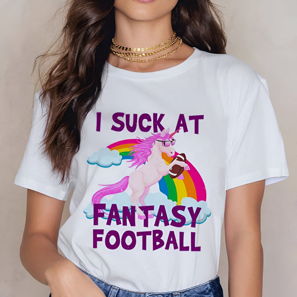 T-shirt blanc avec un motif humoristique : une licorne rose portant des lunettes de soleil, devant un arc-en-ciel, tenant un ballon de football américain. Le texte imprimé dit "I suck at fantasy football"., 45502315036927,45502315069695,45502315102463,45502315135231,45502315167999,45502315200767,45502315233535,45502315266303 | Licorne Shop