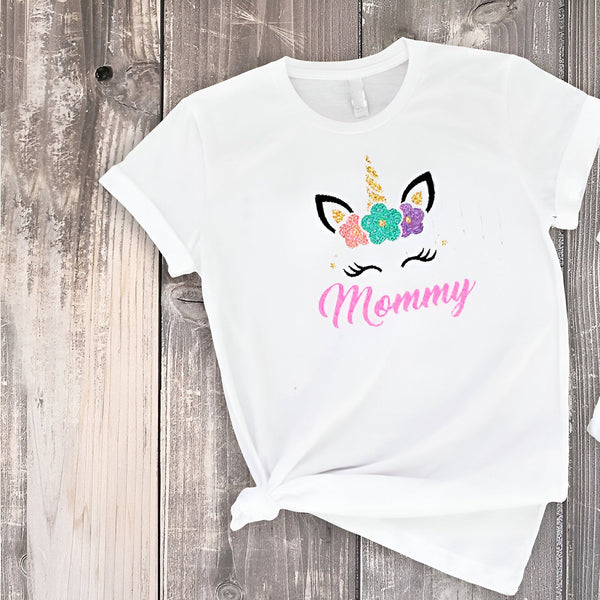 T-shirt blanc avec motif de licorne florale et le mot « Mommy » en rose scintillant. T-shirt pour mamans, design mignon et tendance. Idée cadeau pour la fête des mères., 45502310842623,45502310875391,45502310908159,45502310940927,45502310973695,45502311006463,45502311039231,45502311071999 | Licorne Shop