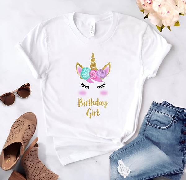 T-shirt blanc avec motif de licorne orné de fleurs et l'inscription "Birthday Girl" en doré, accompagné de lunettes de soleil, chaussures et jean bleu., 45502315299071,45502315331839,45502315364607,45502315397375,45502315430143,45502315462911,45502315495679,45502315528447 | Licorne Shop