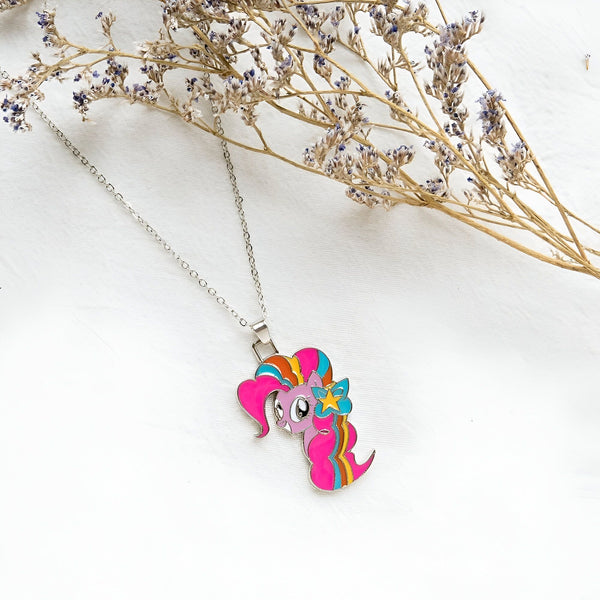 Collier argenté avec pendentif My Little Pony rose, bleu et jaune, sur un fond blanc avec des fleurs séchées. Bijou fantaisie, cadeau pour enfant., 45501761093887 | Licorne Shop