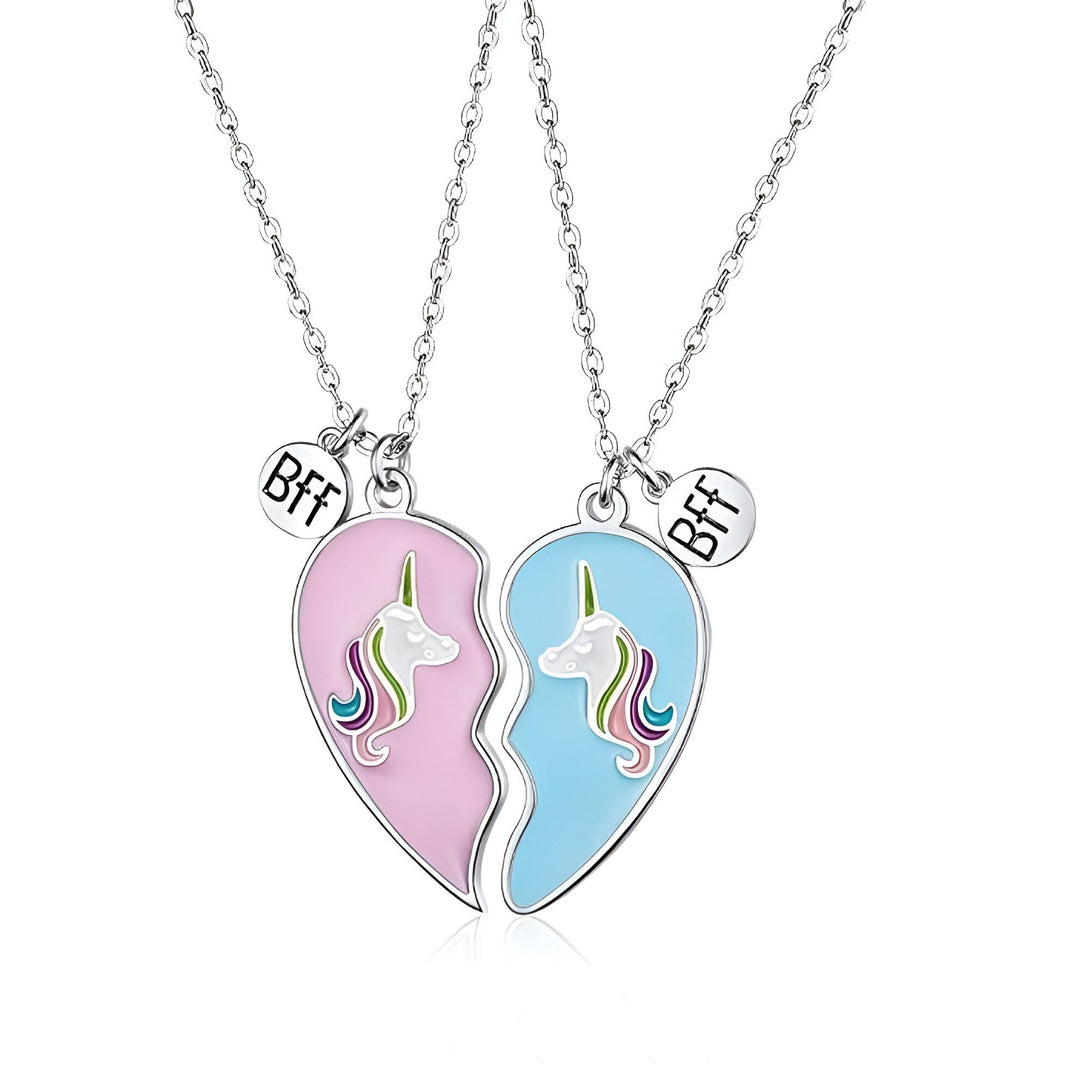 Deux colliers avec pendentifs en forme de cœur brisé. Les pendentifs sont roses et bleus et comportent chacun une licorne. Les colliers sont en argent.