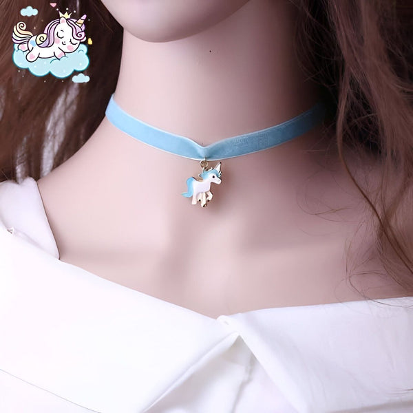 Gros plan d'un collier ras du cou bleu avec un pendentif licorne. Le pendentif est blanc avec des détails bleus et dorés. Un autocollant de licorne est visible en haut à gauche., 45501736812799 | Licorne Shop