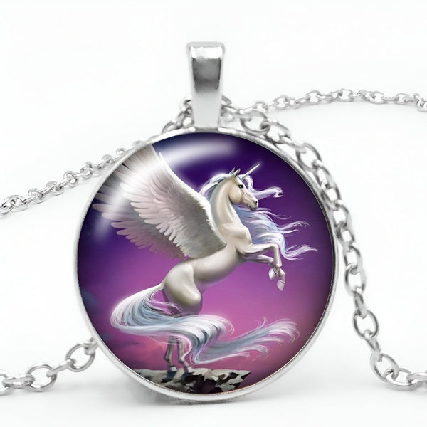 Un pendentif en forme de licorne ailée cabré sur un fond violet. La chaîne est en argent.