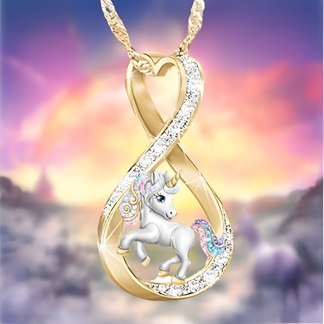 Un pendentif en forme de licorne en or avec des pierres précieuses multicolores sur un fond de ciel rose et bleu.