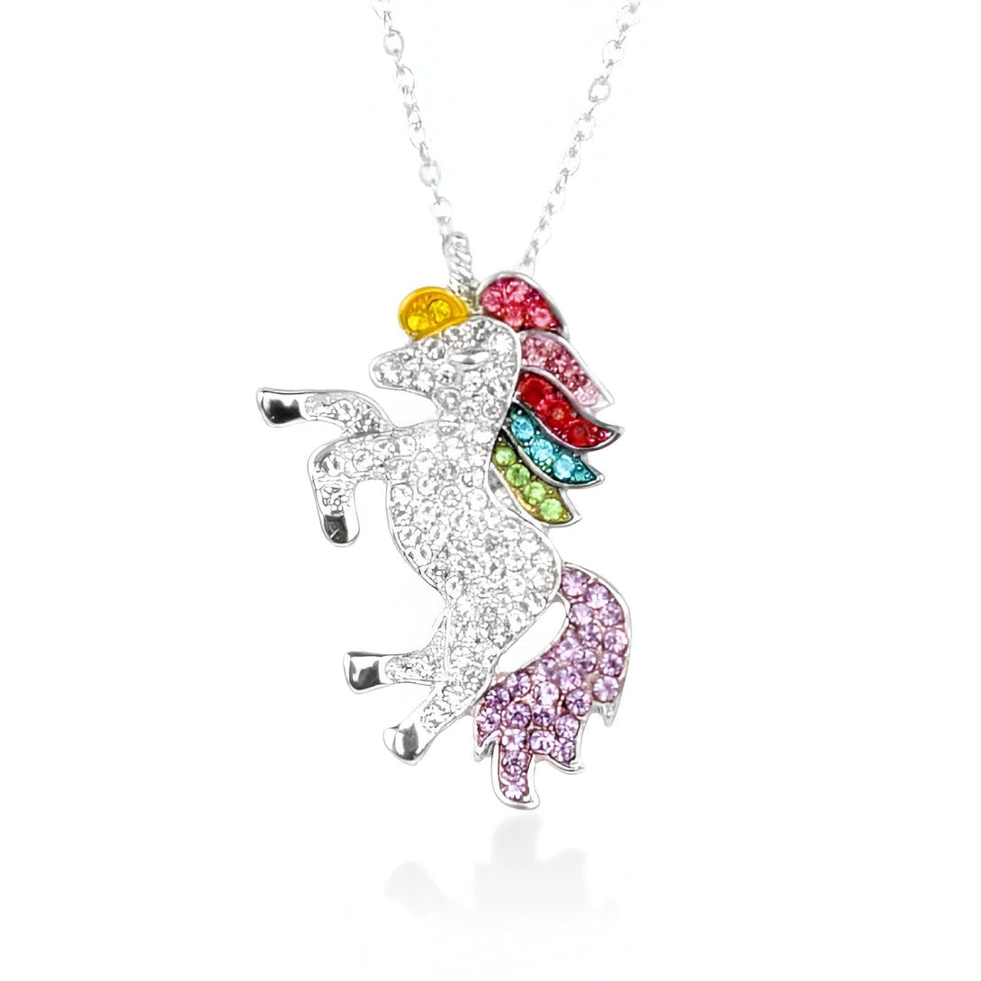 Collier pendentif licorne argenté. Le pendentif licorne est orné de cristaux multicolores formant une crinière arc-en-ciel et une queue violette. La licorne cabrée est entièrement sertie de strass., 45501763518719 | Licorne Shop