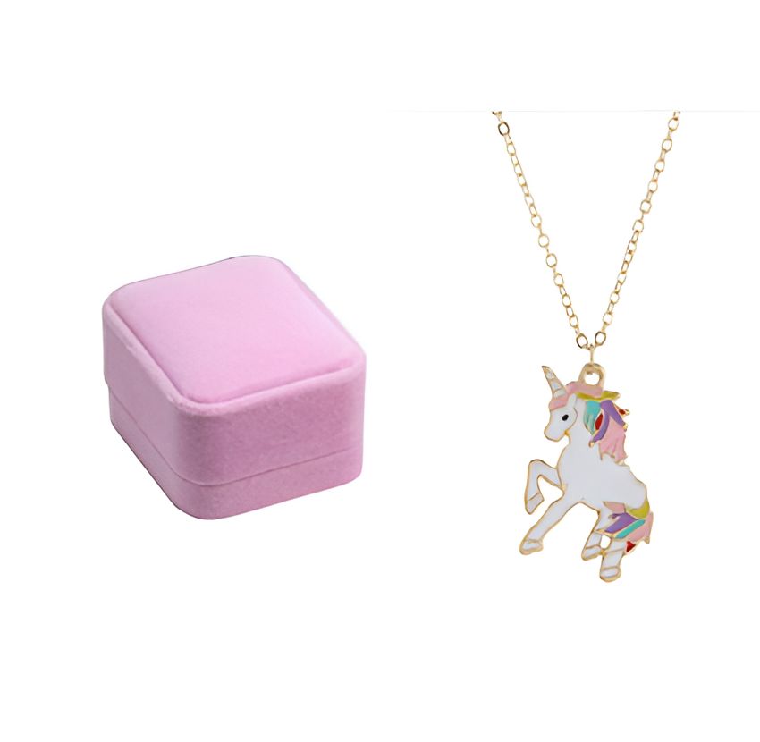 Un collier avec un pendentif licorne est présenté dans un écrin rose. La licorne est blanche avec une crinière et une queue arc-en-ciel.
