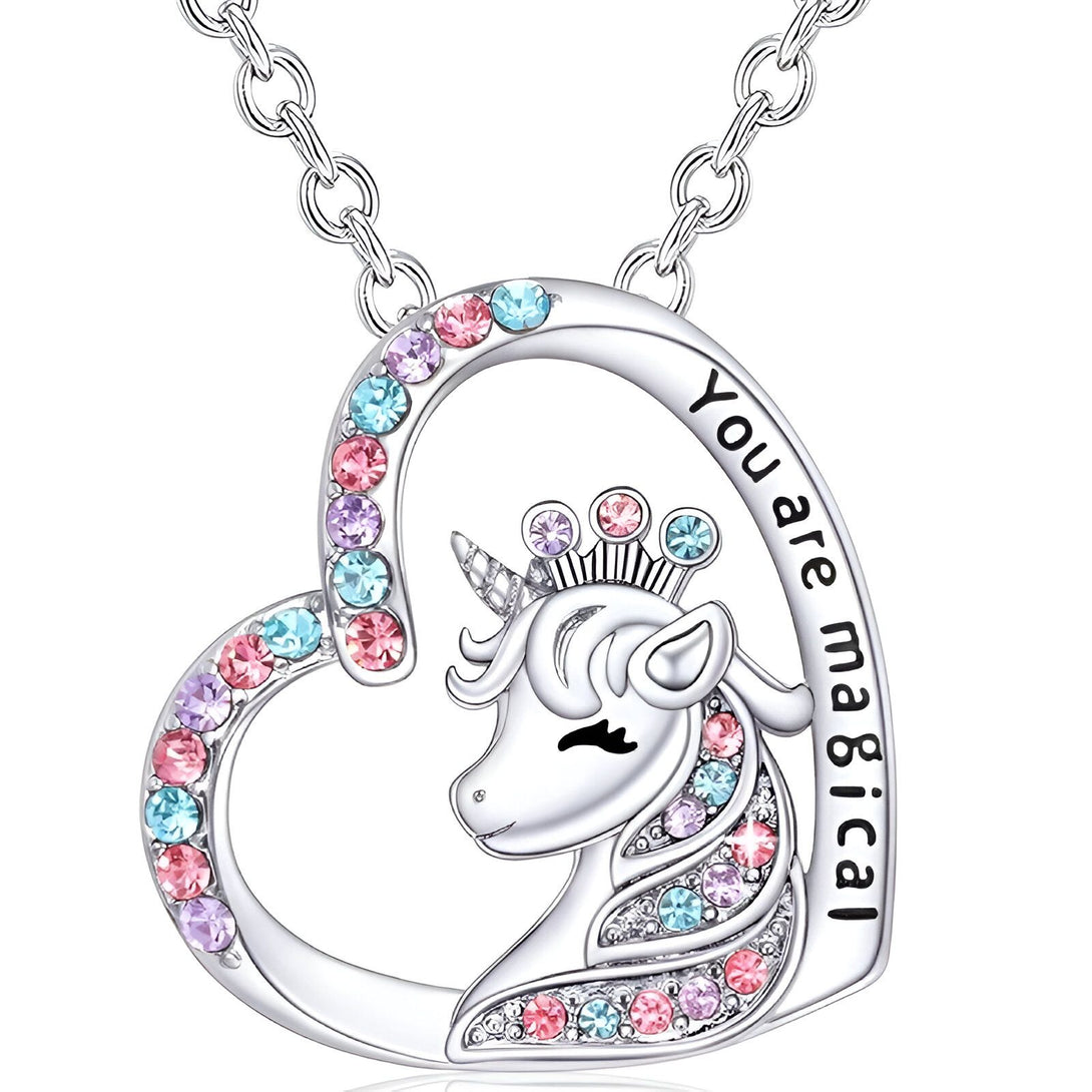 Un collier avec un pendentif en forme de cœur. Le pendentif est serti de cristaux roses, bleus et violets. Il y a une licorne gravée sur le pendentif avec une couronne sur la tête. Le texte "You are magical" est écrit sur le côté droit du pendentif.