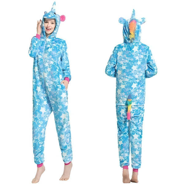 Une femme porte une combinaison pyjama licorne bleue à étoiles blanches. La combinaison est à capuche avec des oreilles de licorne et une crinière arc-en-ciel. Il y a une queue arc-en-ciel à l'arrière de la combinaison.