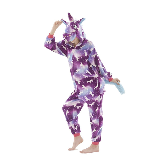 Une personne porte une combinaison pyjama licorne violette avec une capuche et une queue de cheval. La combinaison est imprimée de motifs de licornes et d'étoiles.