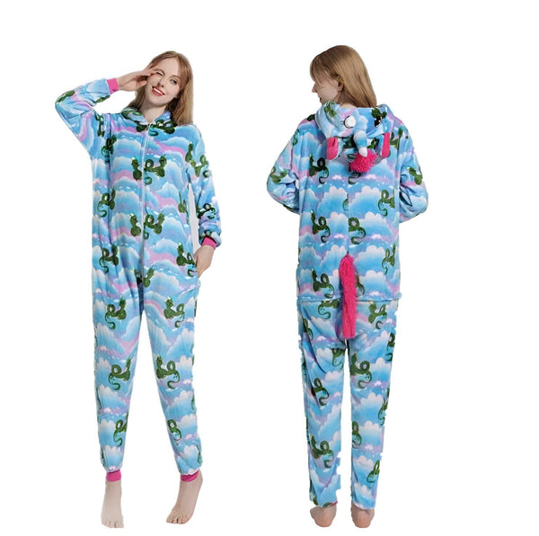 Une femme porte une combinaison pyjama licorne bleue avec une capuche et une queue de cheval rose. La combinaison est imprimée de nuages et de dragons.