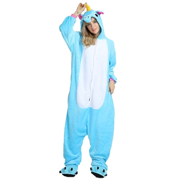 Une jeune femme porte une combinaison pyjama licorne bleue avec une capuche et des pieds. La combinaison est ouverte sur le devant avec une fermeture éclair. La capuche est dotée d'une corne de licorne et d'oreilles roses. Les pieds du pyjama sont en forme de pattes de licorne avec des griffes noires.