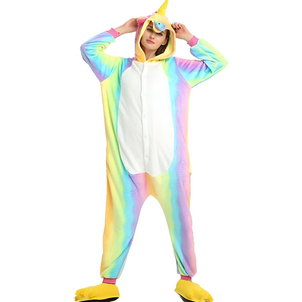Une femme porte un pyjama licorne arc-en-ciel avec une capuche et des pieds jaunes.