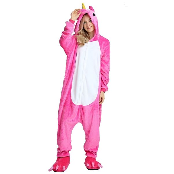 Une femme porte un pyjama licorne rose avec une capuche et des pieds en forme de pattes de licorne.