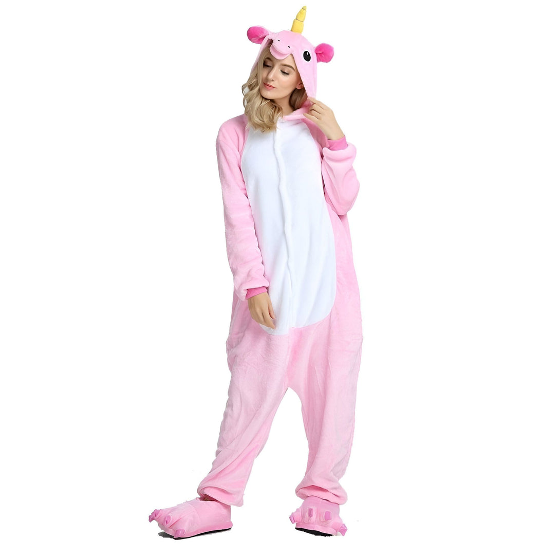 Une femme porte un pyjama licorne rose avec une capuche et des pieds en forme de pattes de licorne.