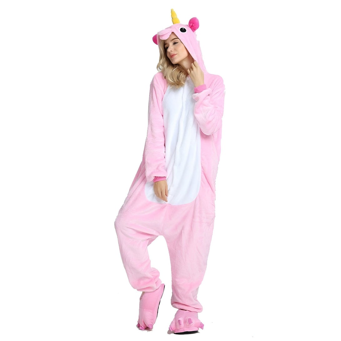 Une femme porte un pyjama licorne rose avec une capuche et des pieds en forme de sabots.