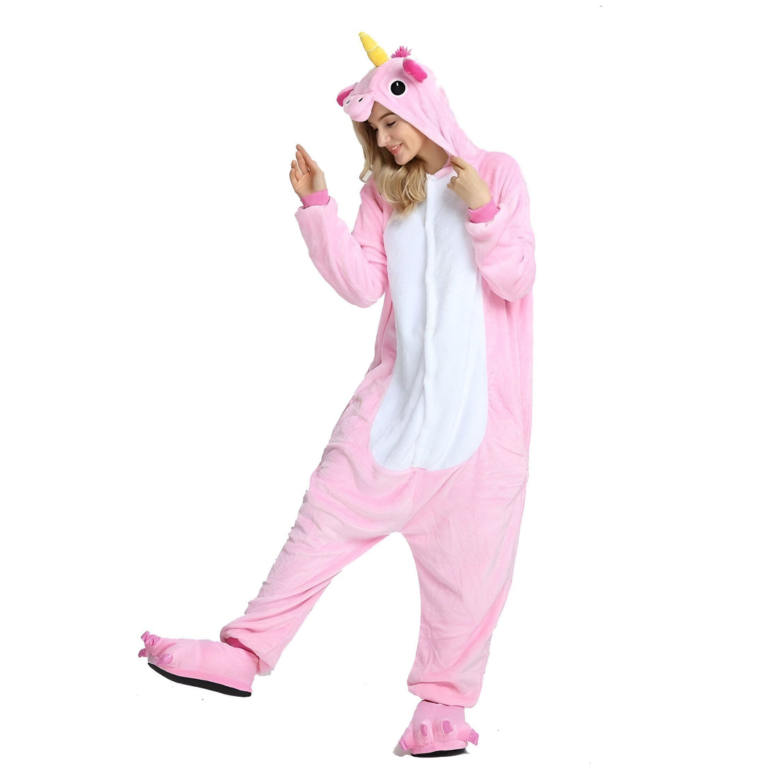 Une femme porte un pyjama licorne rose avec une capuche. Le pyjama a des détails blancs sur le ventre et les pieds. La femme est heureuse et sourit.