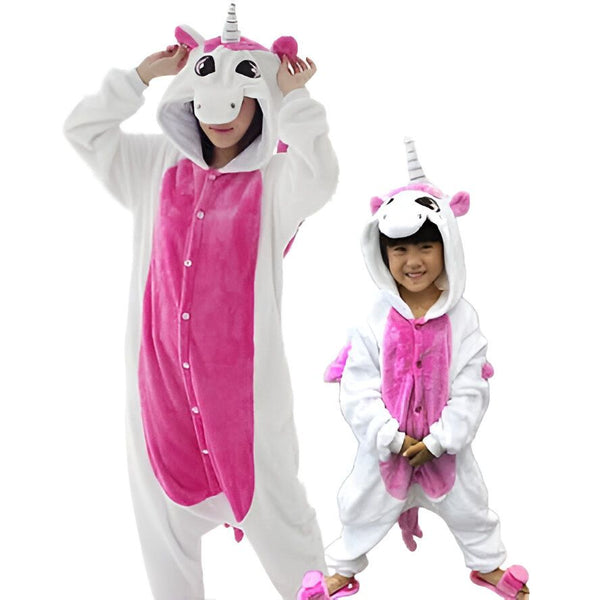 Deux personnes portant des pyjamas licorne blancs et roses. Une femme adulte lève les mains sur sa tête et une petite fille se tient à côté d'elle. Les deux pyjamas sont en polaire douce et ont des cornes et des oreilles de licorne sur la capuche., 45502396727551,45502396760319,45502396793087,45502396825855,45502396858623,45502396891391,45502396924159,45502396956927 | Licorne Shop
