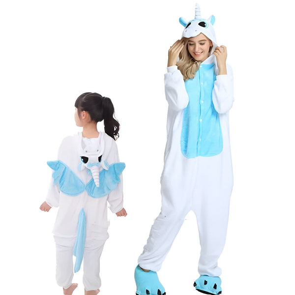 Image de deux personnes portant des pyjamas de licorne blanches et bleues. La femme adulte a un sourire et lève ses mains vers sa tête. L'enfant a les cheveux attachés en queue de cheval et regarde vers la gauche., 45502000693503,45502000726271,45502000759039,45502000791807,45502000824575,45502000857343,45502000890111,45502000922879 | Licorne Shop