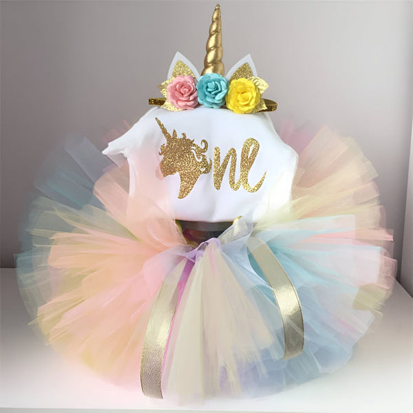 Ensemble licorne pour bébé fille comprenant un body blanc avec l'inscription "one" en doré, un tutu multicolore et un serre-tête avec corne de licorne dorée et fleurs colorées. Parfait pour un anniversaire., 45501289332991,45501289365759,45501289398527,45501289496831,45501289529599,45501289562367,45501289595135,45501289627903 | Licorne Shop