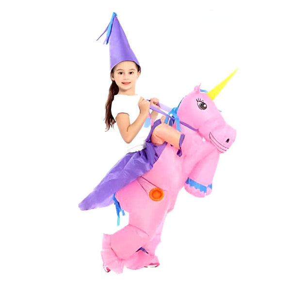 Une fillette souriante, portant un chapeau pointu violet, est déguisée en cavalier d'une licorne gonflable rose avec une corne jaune. Elle tient des rênes bleues. Costumes d'Halloween pour enfants., 45501284745471,45501284778239,45501284811007,45501284843775,45501284876543,45501284909311,45501284942079,45501284974847 | Licorne Shop