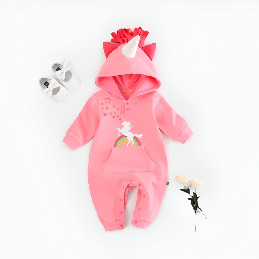 Combinaison bébé rose avec capuche et motif licorne sur un arc-en-ciel, accompagnée de petites chaussures et de fleurs blanches. Vêtement doux et adorable pour les tout-petits., 45501212131583,45501212164351,45501212197119,45501212229887,45501212262655,45501212295423,45501212328191,45501212360959 | Licorne Shop
