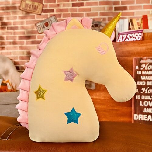 Coussin décoratif en forme de tête de licorne jaune pâle avec corne dorée et crinière rose. Étoiles colorées ornent le corps de la licorne. Objet de décoration intérieure tendance sur un canapé, ambiance chaleureuse et fantaisiste.
, 45501062709503 | Licorne Shop