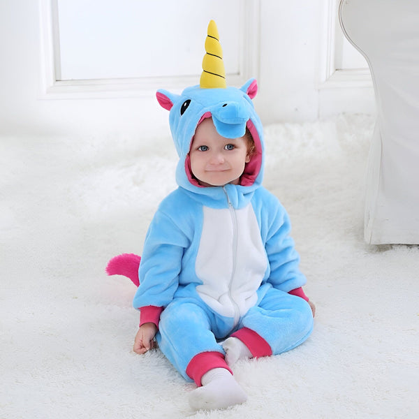 Un bébé souriant porte une combinaison pyjama bleue et blanche d'une licorne, avec une capuche ornée d'une corne jaune., 45501210263807,45501210296575,45501210329343,45501210362111,45501210394879,45501210427647,45501210460415,45501210493183 | Licorne Shop
