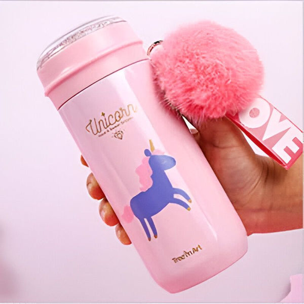 Bouteille rose avec un motif licorne, tenue par une main. Un pompon rose et un porte-clés "LOVE" sont attachés. Idéal pour l'école, le sport, les voyages., 45501173989631 | Licorne Shop