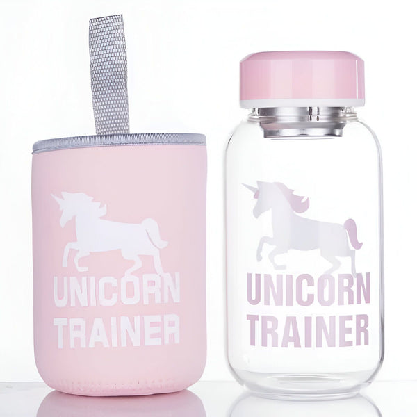 Gourde et son étui rose pastel décorés avec un motif de licorne et l'inscription "Unicorn Trainer". La gourde est en verre transparent avec un bouchon rose., 45501176742143 | Licorne Shop