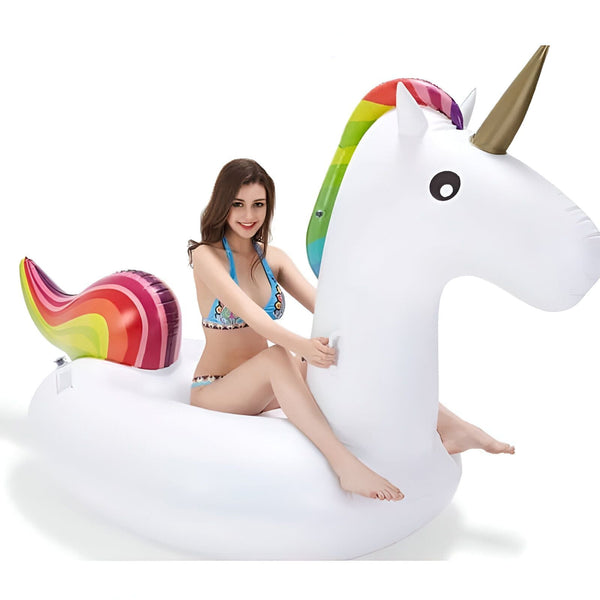 Une femme en maillot de bain assise sur une bouée gonflable licorne blanche avec des détails arc-en-ciel, idéale pour la piscine ou la plage. Amusez-vous avec ce jouet d'eau., 45501228155135 | Licorne Shop