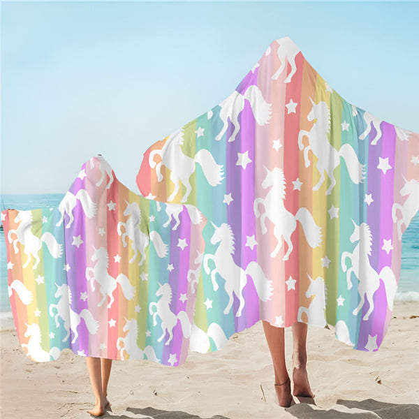 Deux personnes sur la plage portent des serviettes à capuche colorées à rayures arc-en-ciel ornées de motifs de licornes blanches et d'étoiles., 45501254893823 | Licorne Shop