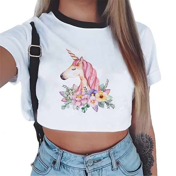 Gros plan d'un T-shirt court blanc orné d'un motif de licorne rose et de fleurs colorées. Le t-shirt est porté par une femme en jean taille basse, avec une bretelle noire visible sur l'épaule., 45501297623295 | Licorne Shop