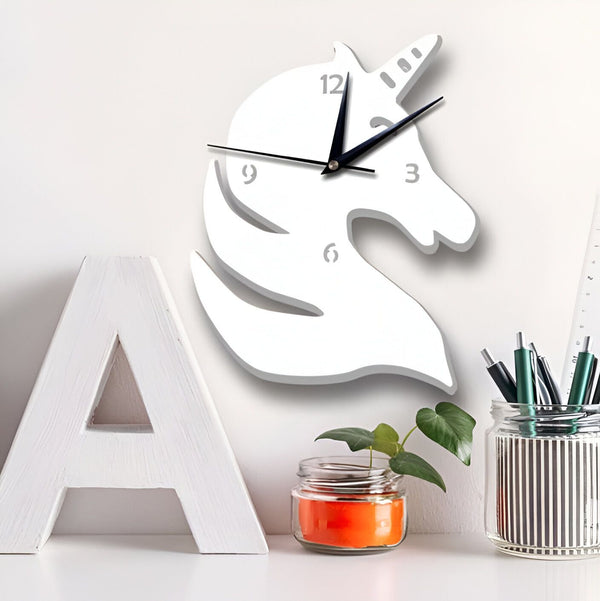 Gros plan sur une horloge murale en forme de tête de licorne blanche, entourée d'une lettre A blanche, d'une petite plante en pot et d'un pot à crayons rayé. Décoration intérieure ludique et moderne., 45501134930175 | Licorne Shop