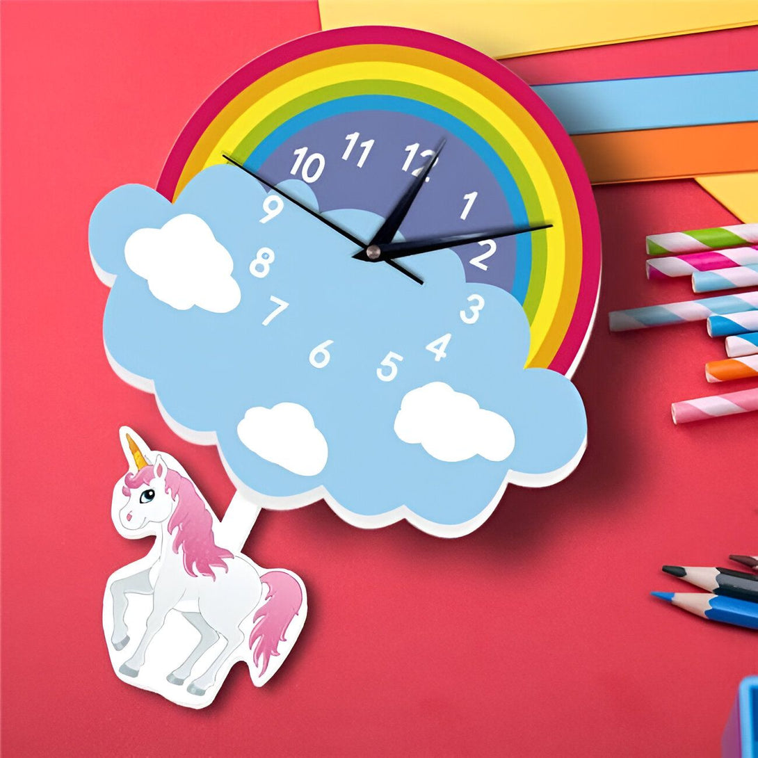 Horloge murale enfantine avec motif arc-en-ciel et nuages bleus. Un sticker d'un licorne rose et blanc est collé. Des pailles rayées et des crayons colorés ajoutent une touche ludique., 45501137617151 | Licorne Shop