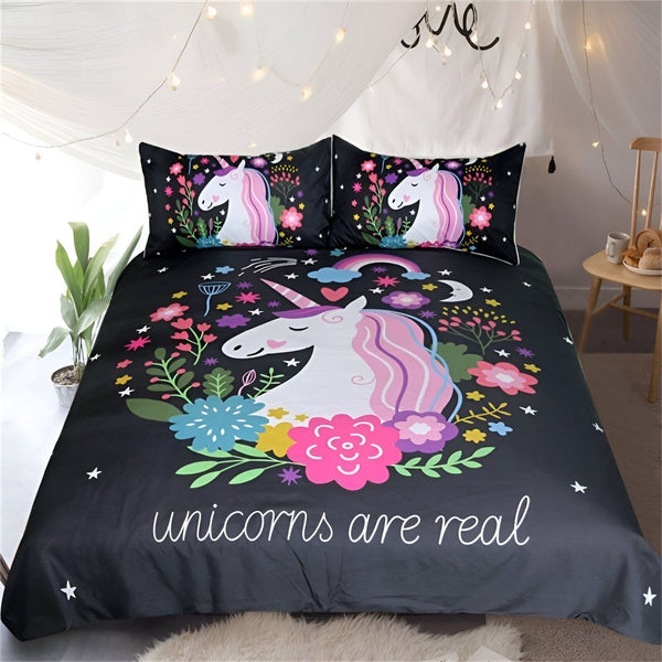 Une couette noire avec des licornes roses et des fleurs colorées. Le texte "unicorns are real" est écrit en bas de la couette.