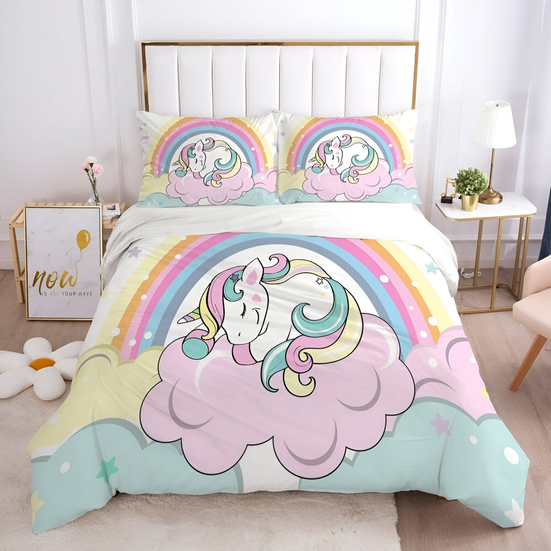 Une chambre d'enfant avec une parure de lit licorne. La parure de lit est composée d'une housse de couette, d'un drap et d'une taie d'oreiller. La housse de couette est imprimée d'un motif de licorne endormie sur un nuage. Le drap est imprimé d'un motif de nuages et d'étoiles. La taie d'oreiller est imprimée d'un motif de licorne.