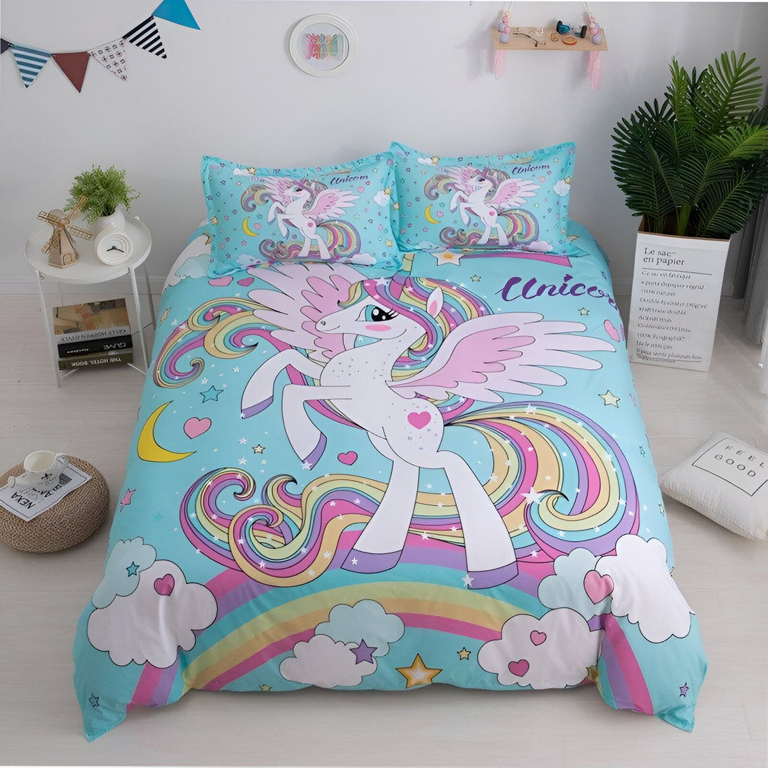 Une chambre d'enfant avec une parure de lit licorne. La parure de lit est composée d'une housse de couette, d'un drap et d'une taie d'oreiller. La housse de couette est imprimée d'un motif de licorne avec des ailes et une crinière arc-en-ciel. Le drap est imprimé d'un motif de nuages et d'étoiles. La taie d'oreiller est imprimée d'un motif de licorne.