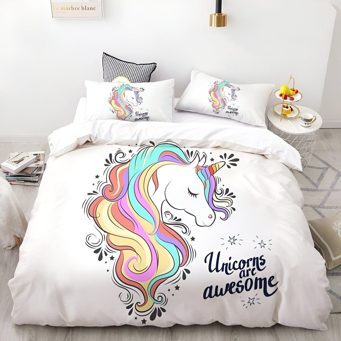 Une couette blanche avec une taie d'oreiller assortie. La couette présente un motif de licorne avec une crinière arc-en-ciel et des étoiles. La taie d'oreiller assortie présente le même motif de licorne.