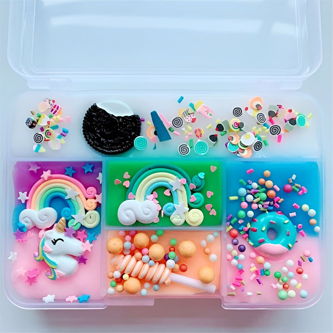 Boîte de rangement transparente remplie de slime coloré et de décorations amusantes : arcs-en-ciel, licorne, bonbons, et vermicelles. Idéal pour l'artisanat et le jeu créatif., 45501395271935 | Licorne Shop