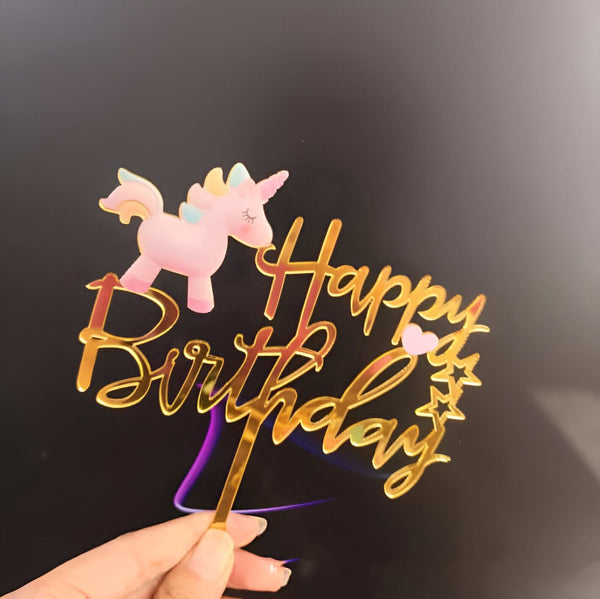 Décoration de gâteau d'anniversaire avec un joli motif d'un licorne rose et dorée, parfait pour une fête d'enfant. L'inscription "Happy Birthday" en lettres dorées ajoute une touche festive., 45502414225663 | Licorne Shop