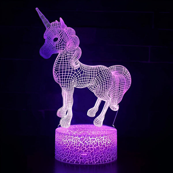 Une veilleuse licorne en 3D avec un éclairage LED violet. La licorne est debout sur un socle fissuré qui sert également d'interrupteur.