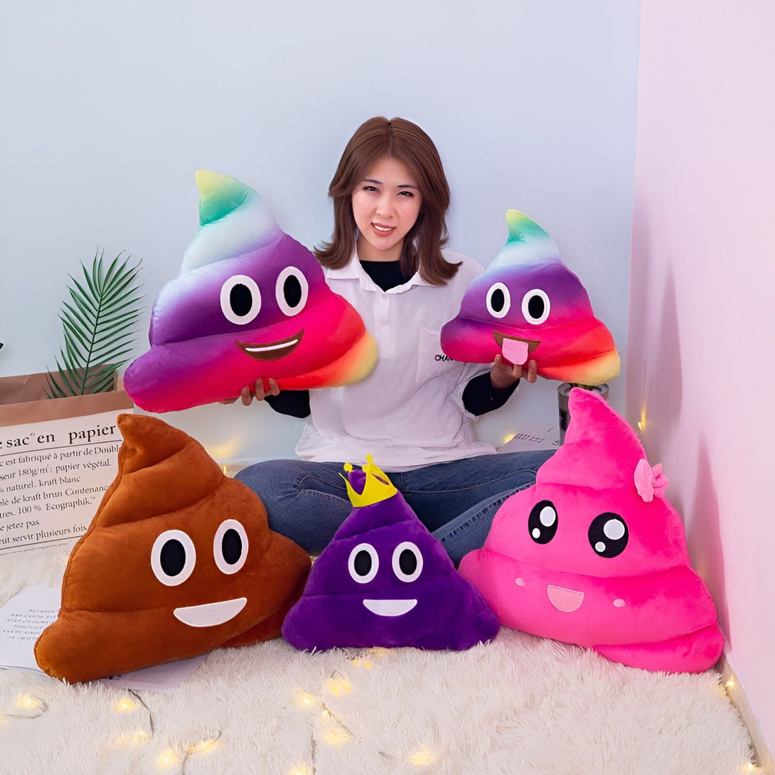 Une femme souriante est assise entourée de coussins emoji caca colorés (marron, violet, rose, arc-en-ciel). Cadeaux originaux, décoration insolite, humour., 45501049405695 | Licorne Shop