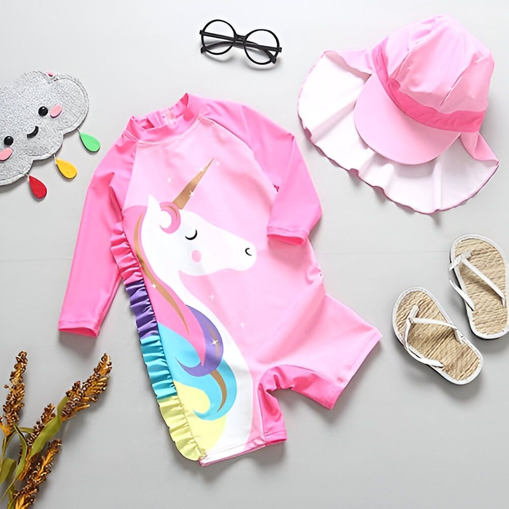 Maillot de bain rose pour enfant avec motif de licorne, accompagné d'un chapeau de soleil rose, de lunettes rondes, de tongs et d'un nuage décoratif. Ensemble parfait pour une journée à la plage ou à la piscine., 45501237919999 | Licorne Shop