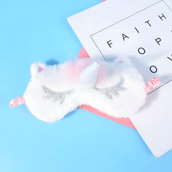 Masque de sommeil licorne blanc et duveteux avec des cils argentés brillants sur fond bleu avec un papier rose et blanc portant les mots "FAITH", "HOPE", "LOVE", 45501053567231 | Licorne Shop