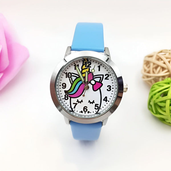 Montre pour enfant avec un bracelet bleu clair. Le cadran de la montre représente une licorne blanche avec une crinière arc-en-ciel et un nœud rose. Les chiffres sont clairement visibles sur le cadran., 45501128737023 | Licorne Shop