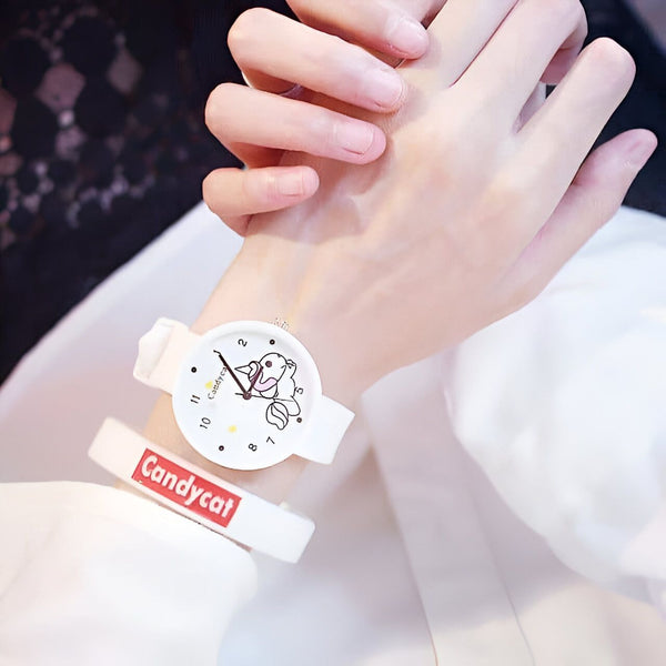 Main sur laquelle est portée une montre blanche avec un dessin de poisson. Bracelet blanc avec le mot "Candycat". Mode enfantine., 45501968122111 | Licorne Shop