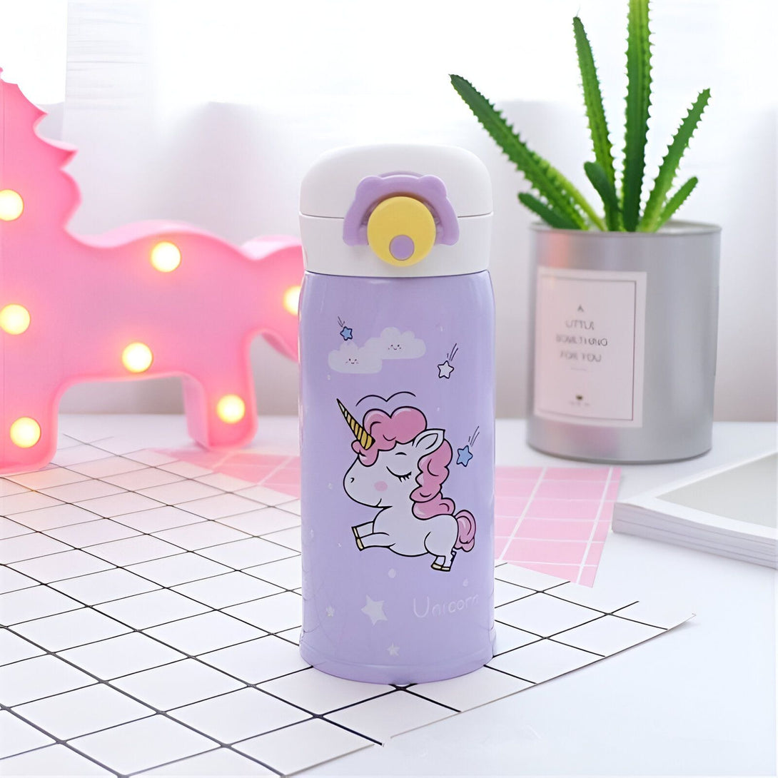 Une bouteille thermos en acier inoxydable avec un motif de licorne. La bouteille est de couleur violette et la licorne est blanche avec une crinière et une queue roses. Il y a aussi des étoiles et des nuages sur la bouteille.