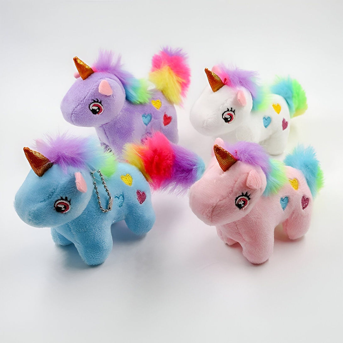 Quatre peluches de licornes colorées avec des crinières et des queues arc-en-ciel.