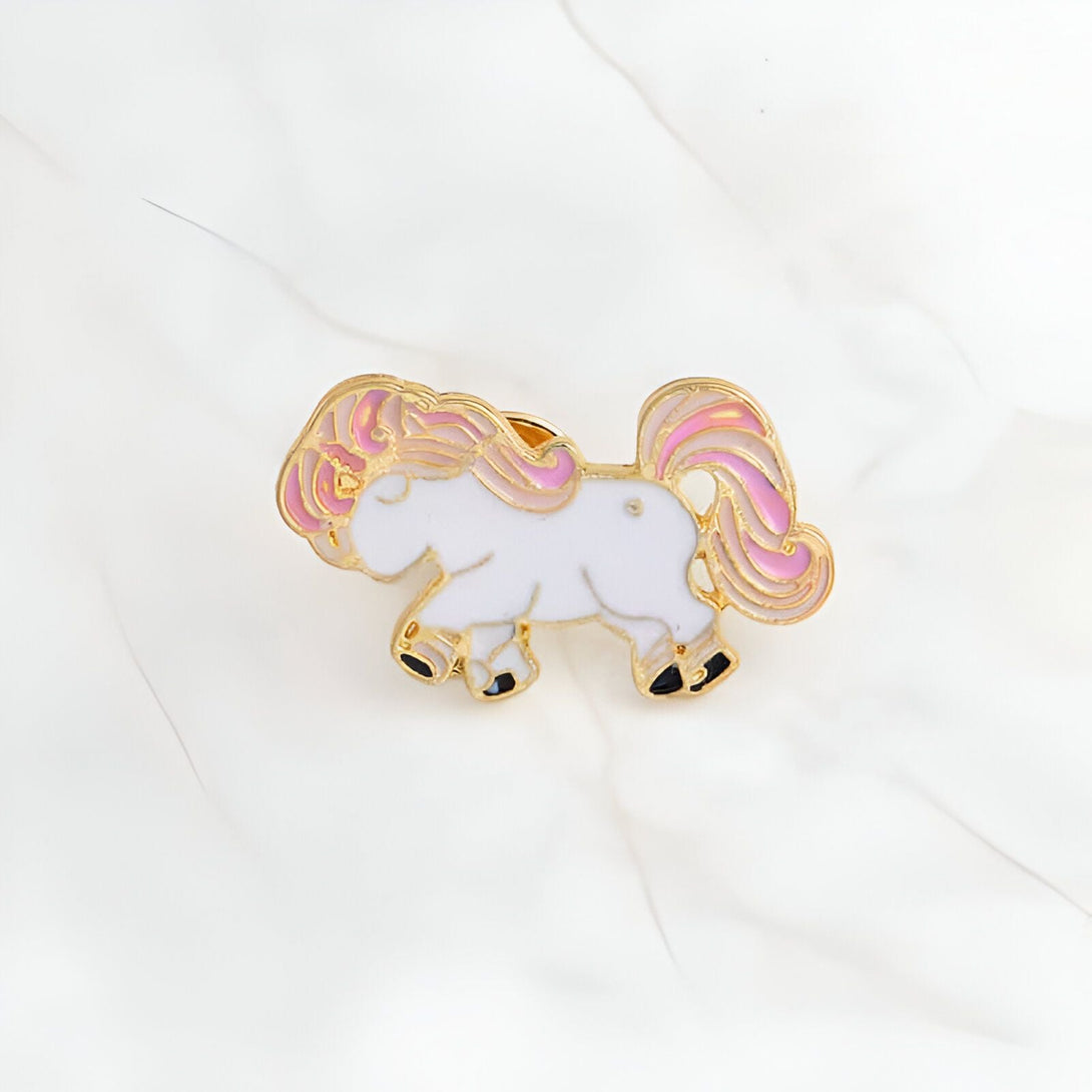 Broche émaillée d'un poney blanc avec une crinière et une queue roses et des bordures dorées. Accessoire mignon pour personnaliser un sac ou une veste. Bijou fantaisie pour les amoureux des chevaux., 45501796450559 | Licorne Shop